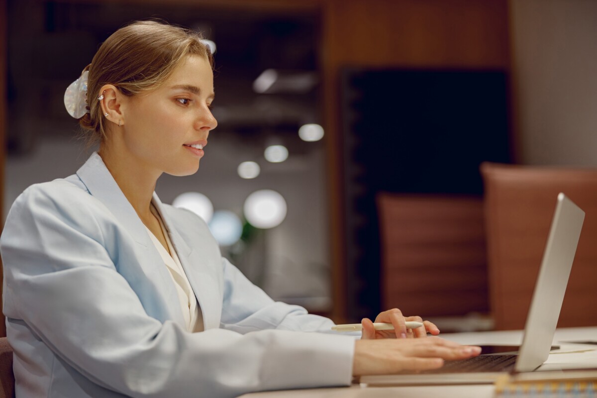 A dedicated businesswoman is focused on her laptop in a modern office, leveraging tech to advance paycheck advance lincoln