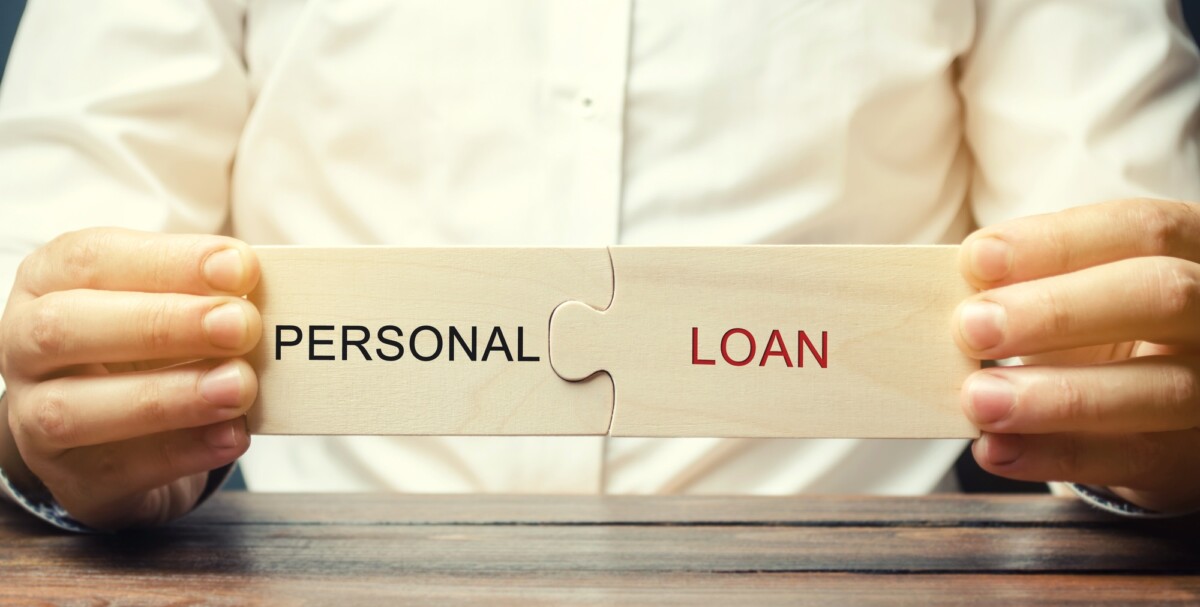 A man collects wooden puzzles with the word Personal Loan A man collects wooden puzzles with the word Personal Loan