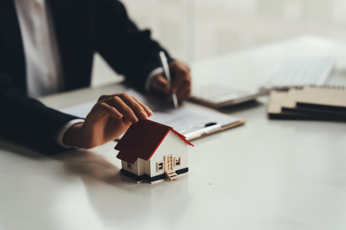 Real Estate Broker Or businessman holding white house model in hand.Mortgage loan approval home loan Real Estate Broker Or businessman holding white house model in hand.Mortgage loan approval home loan