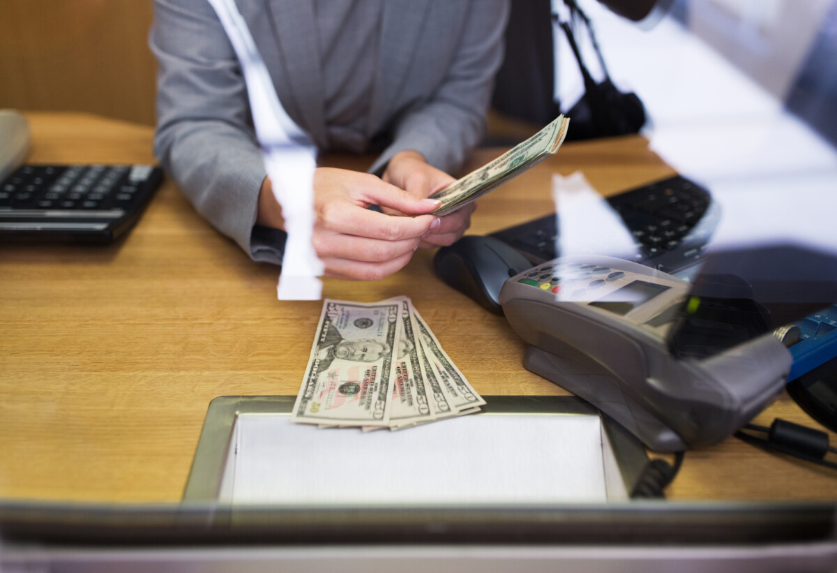 clerk giving cash money to customer at bank office