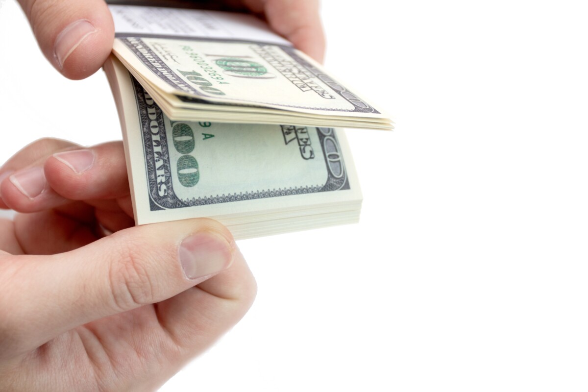 hand-holding-a-bundle-of-dollars-isolated-on-white-2024-10-30-19-06-49-utc