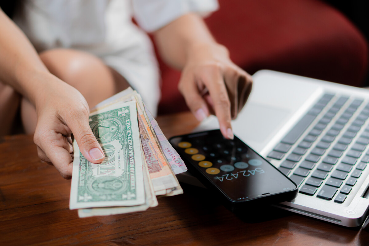 Young woman checking bills, taxes, bank account balance and calc